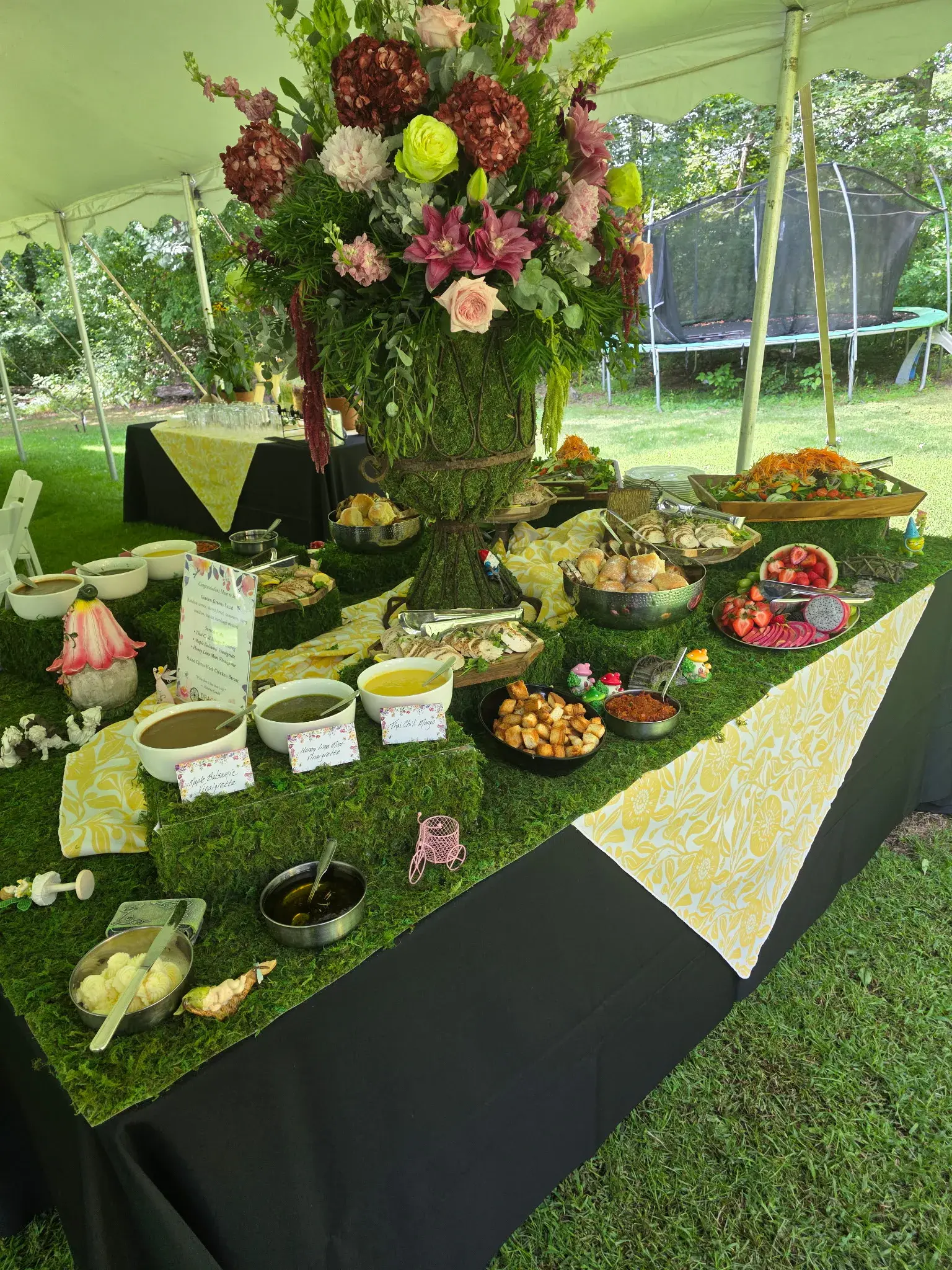 A whimsical garden catering table with floral decor and a seasonal buffet by Dragonfly Catering