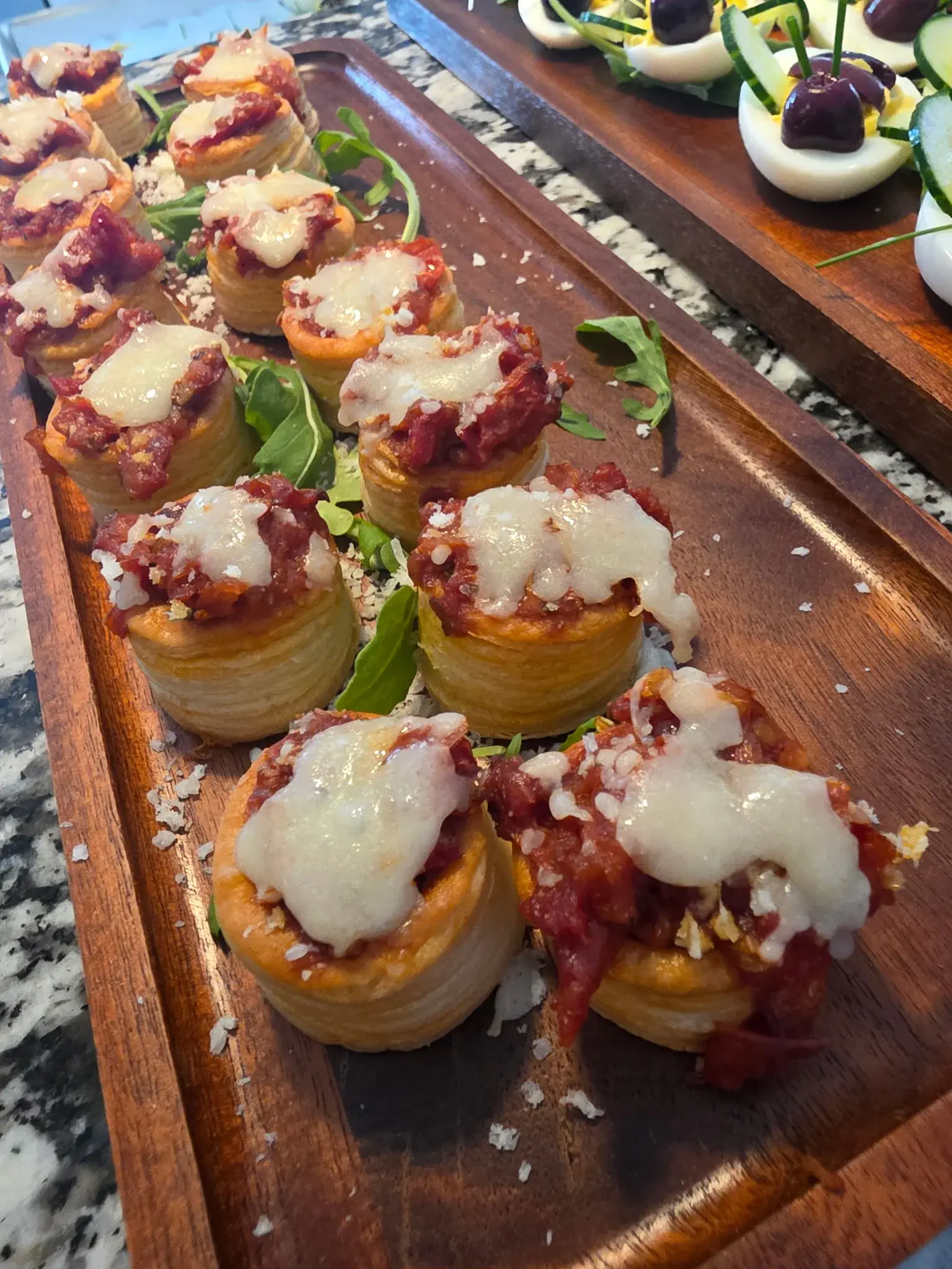 Savory puff pastry bites with tomato and melted cheese prepared by Dragonfly Catering