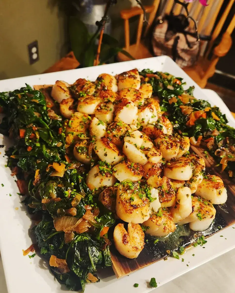 Seared scallops with greens and roasted vegetables prepared by Dragonfly Catering