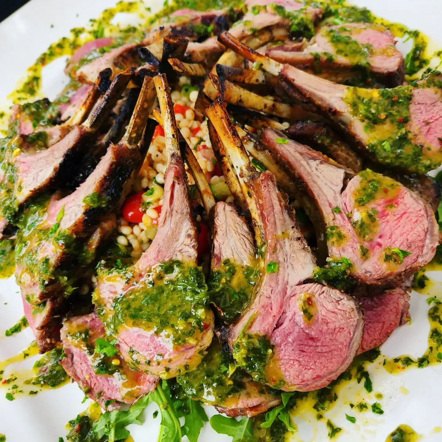 Herb-crusted rack of lamb sliced and plated by Dragonfly Catering