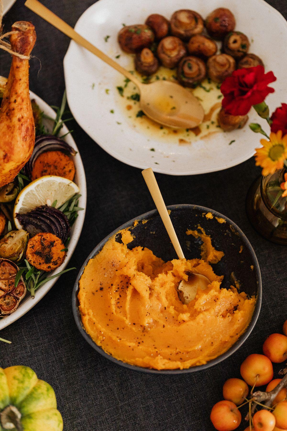 Thanksgiving spread with whipped squash, roasted vegetables and small pumpkins